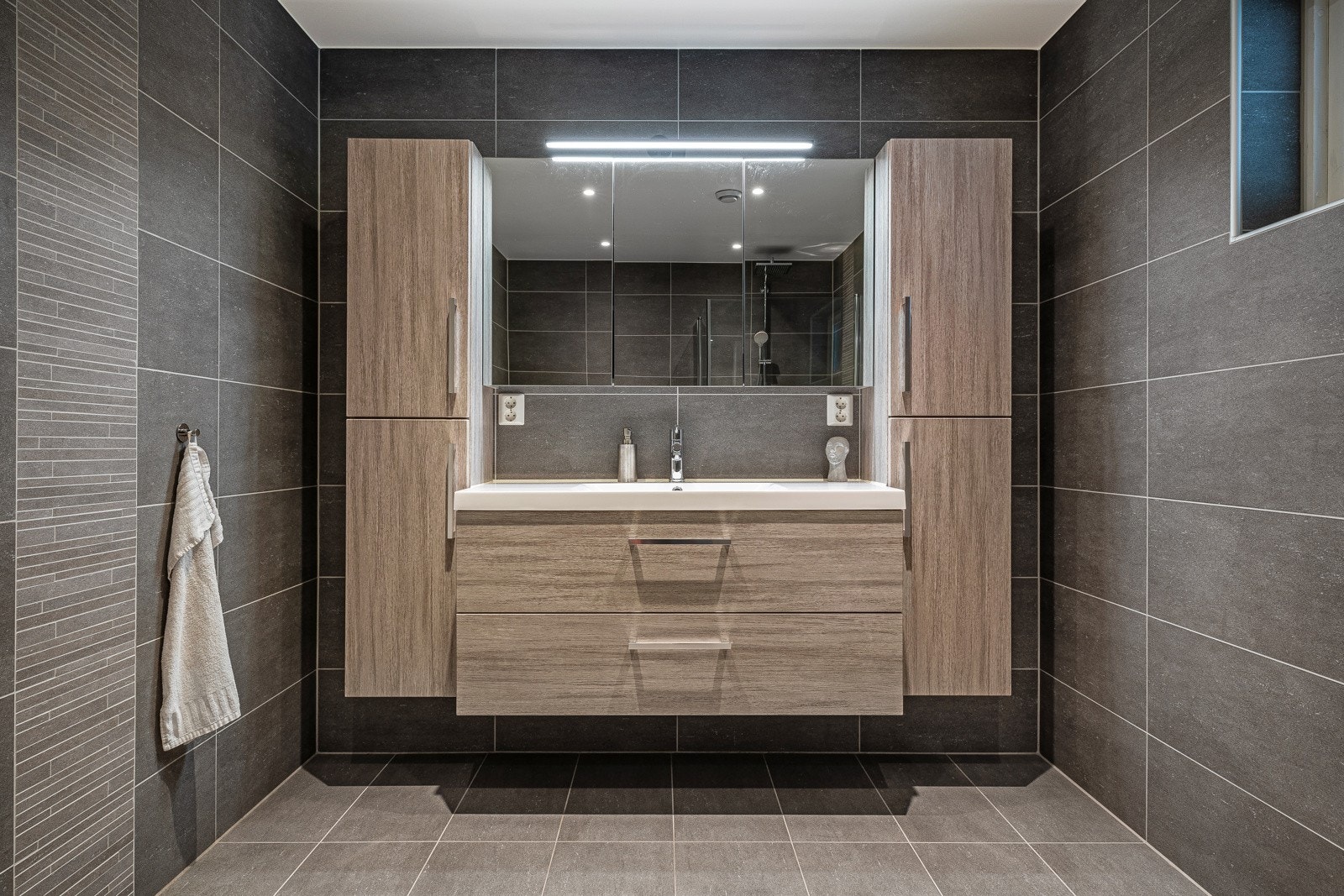 Baderomsmøbel med skuffefronter og heldekkende servant i akrylmateriale. Tilhørende vegg/høyskap. Speilskap med lys. Galleribilde