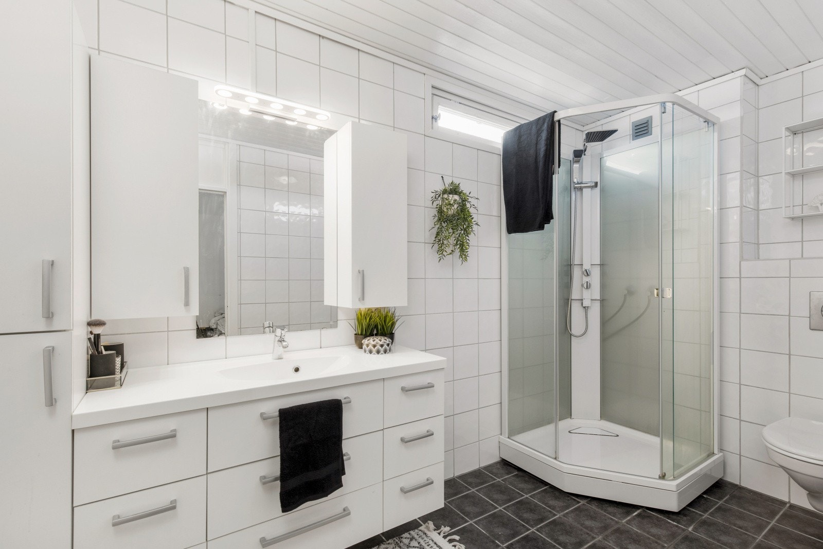 Bad i 1. etasje med flislagte overflater og varme i gulv. Rommet ble oppgradert i 2007. Galleribilde