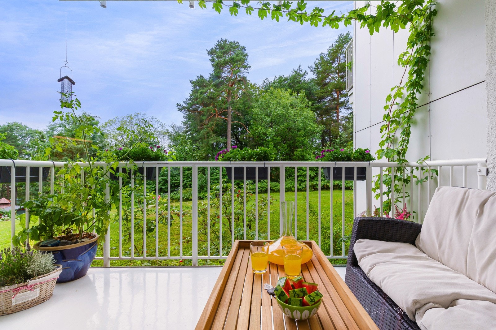 Svært idyllisk utsyn fra balkong med stor, frodig gressplen, beplantning, busker og trær. Galleribilde