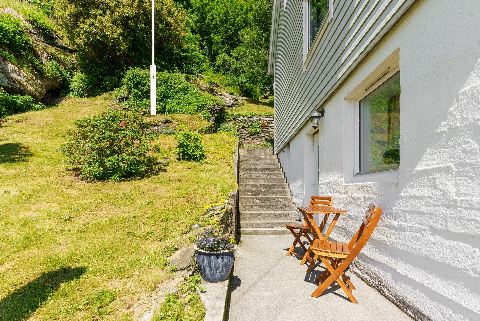 Pent etablert uteområde med gruset og støpt gangvei samt trapp opp til boligens 1. etasje. Galleribilde