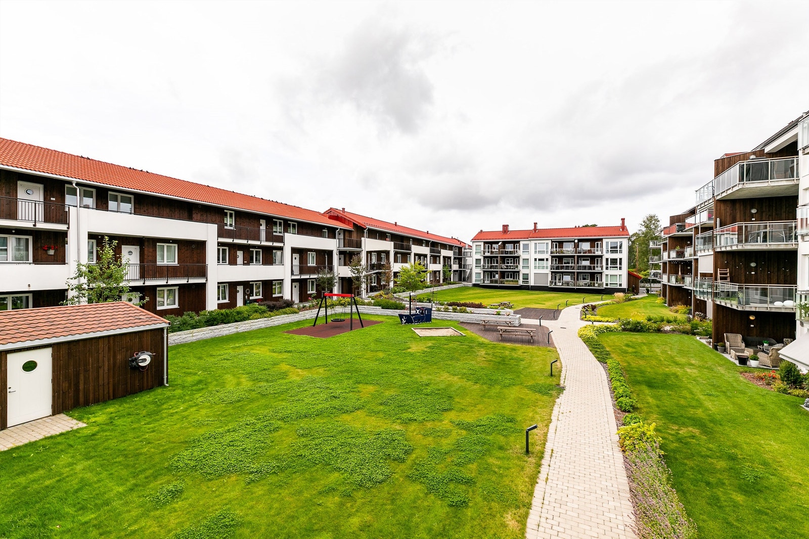 Utsyn fra svalgangen mot atriumet med sittegrupper og lekeplass. Galleribilde