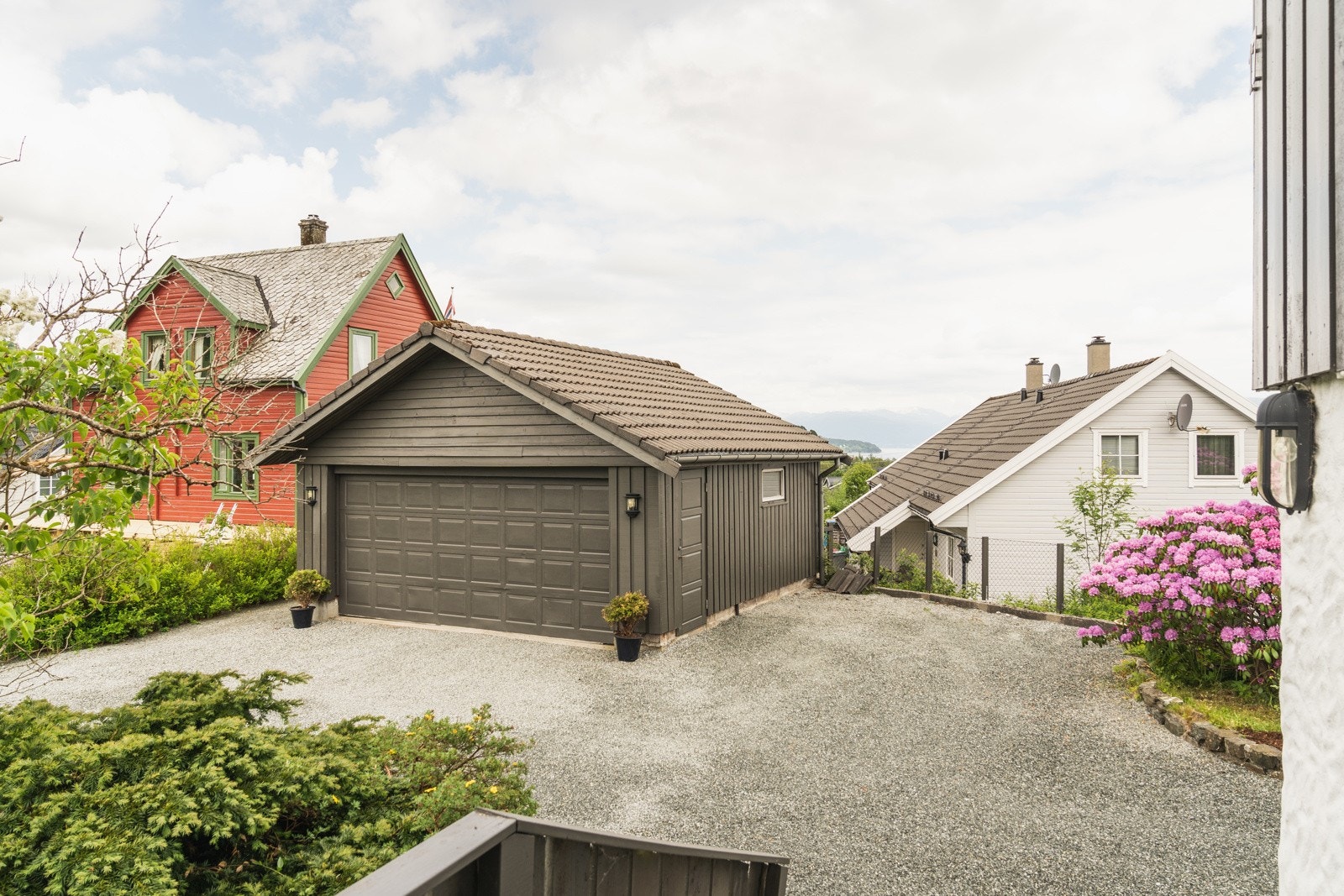 Det er dobbel parkering i garasje, ellers er det god plass til flere biler på gårdsplassen. Galleribilde
