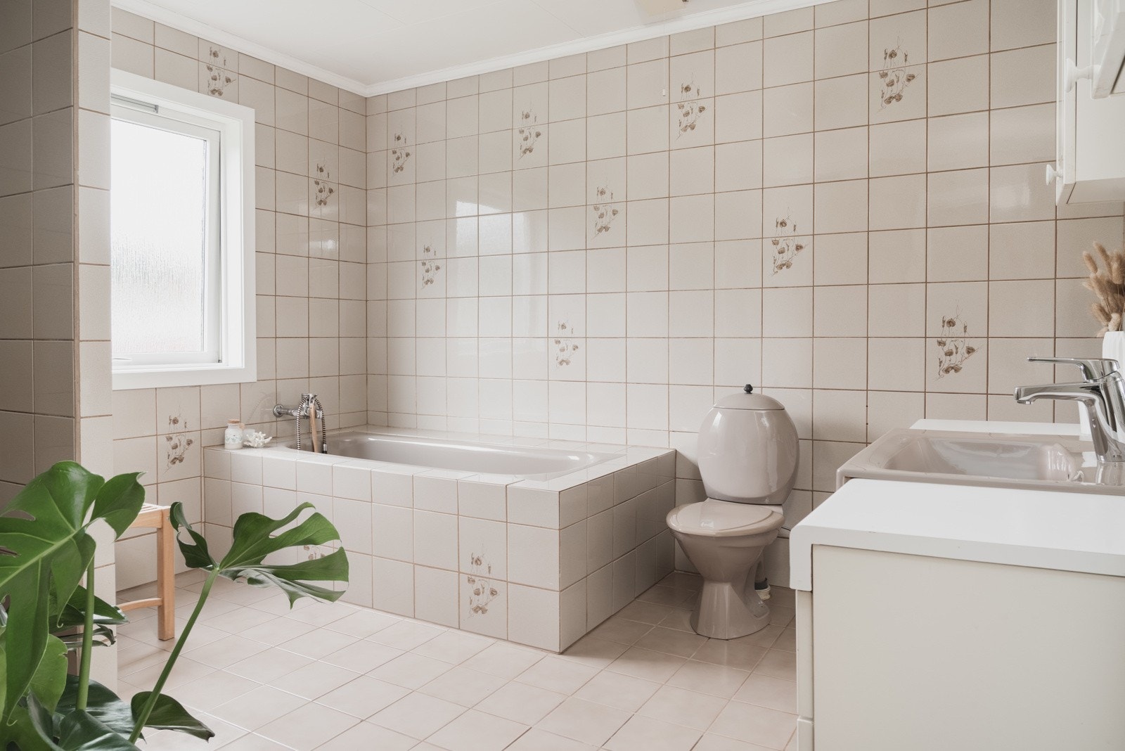 Badet har en eldre baderomsinnredning som består av badekar, gulvstående toalett, bidé og et baderomsmøbel med tilhørende speil og heldekkende servant. Galleribilde