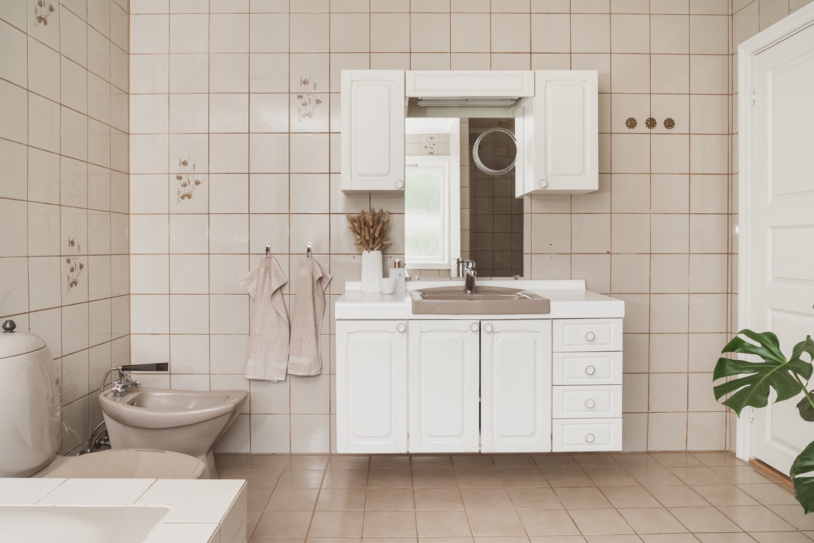 Romslig og helfliset bad på 10 kvm med varmekabler i gulv og et behagelig lysinnslipp. Galleribilde