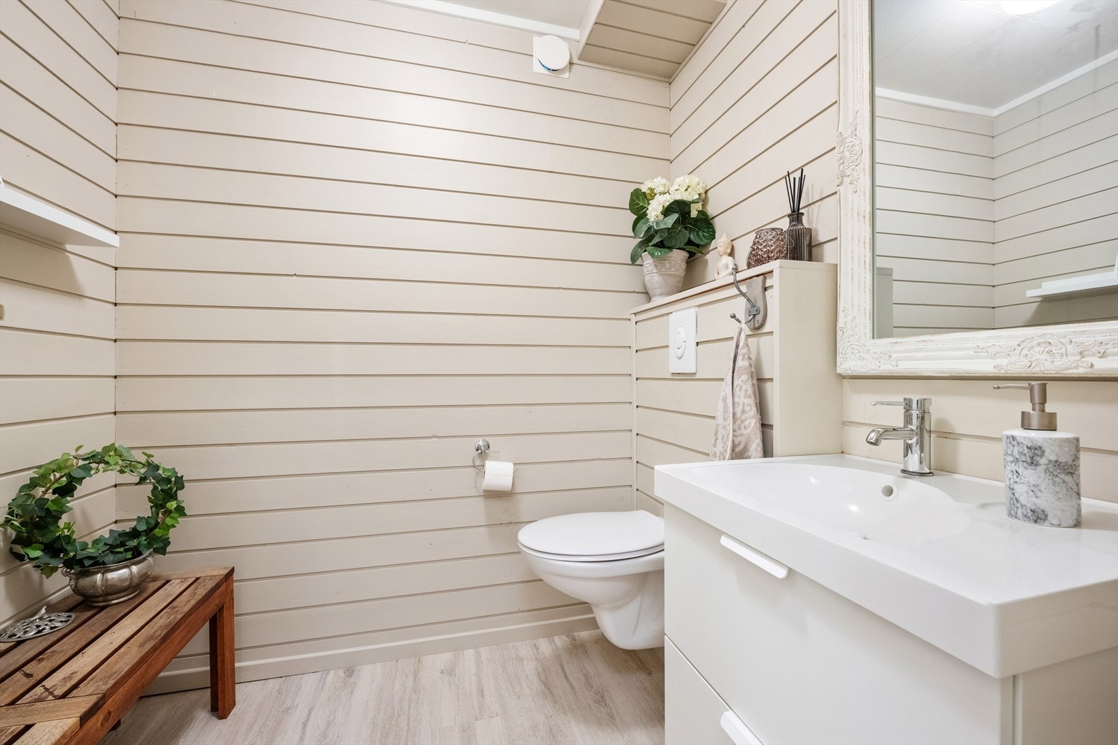 I 1. etasje er det et lyst toalettrom med laminat gulv Galleribilde