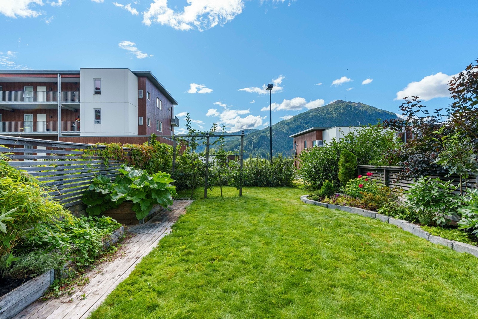 Pent opparbeidet hageområde med blant annet plen, blomster og diverse busker. Et ypperlig sted for rekreasjon. Galleribilde