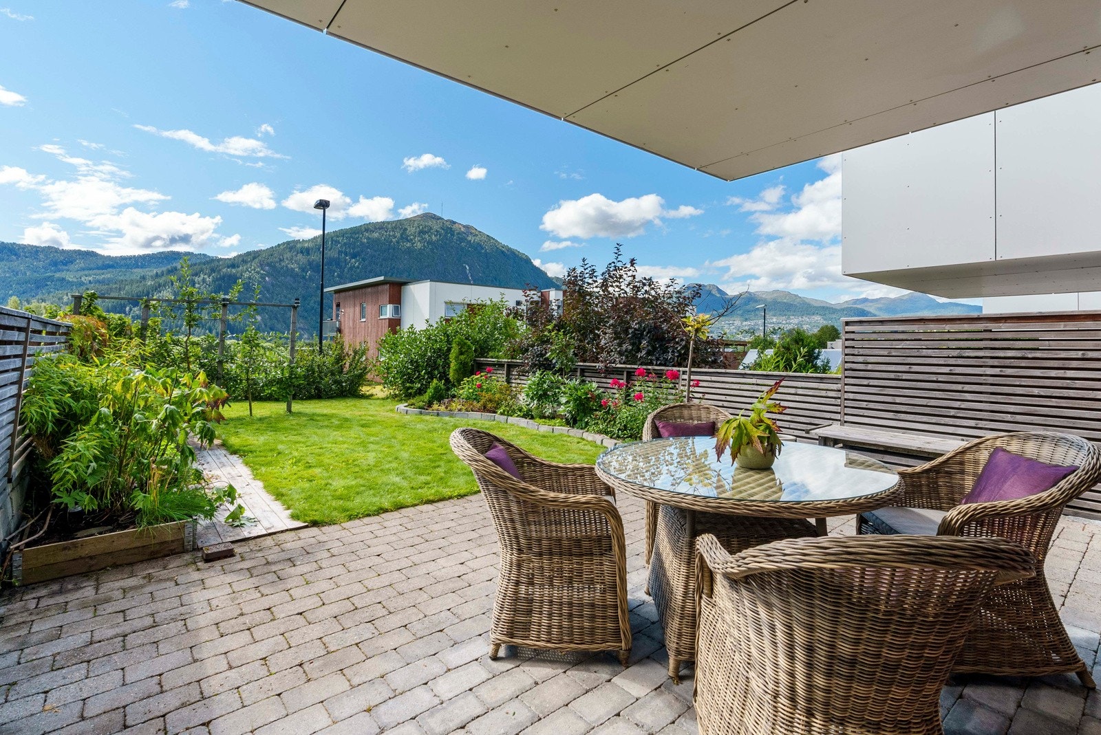 Stor terrasse med belegningsstein med fin oversikt over hagen. Galleribilde