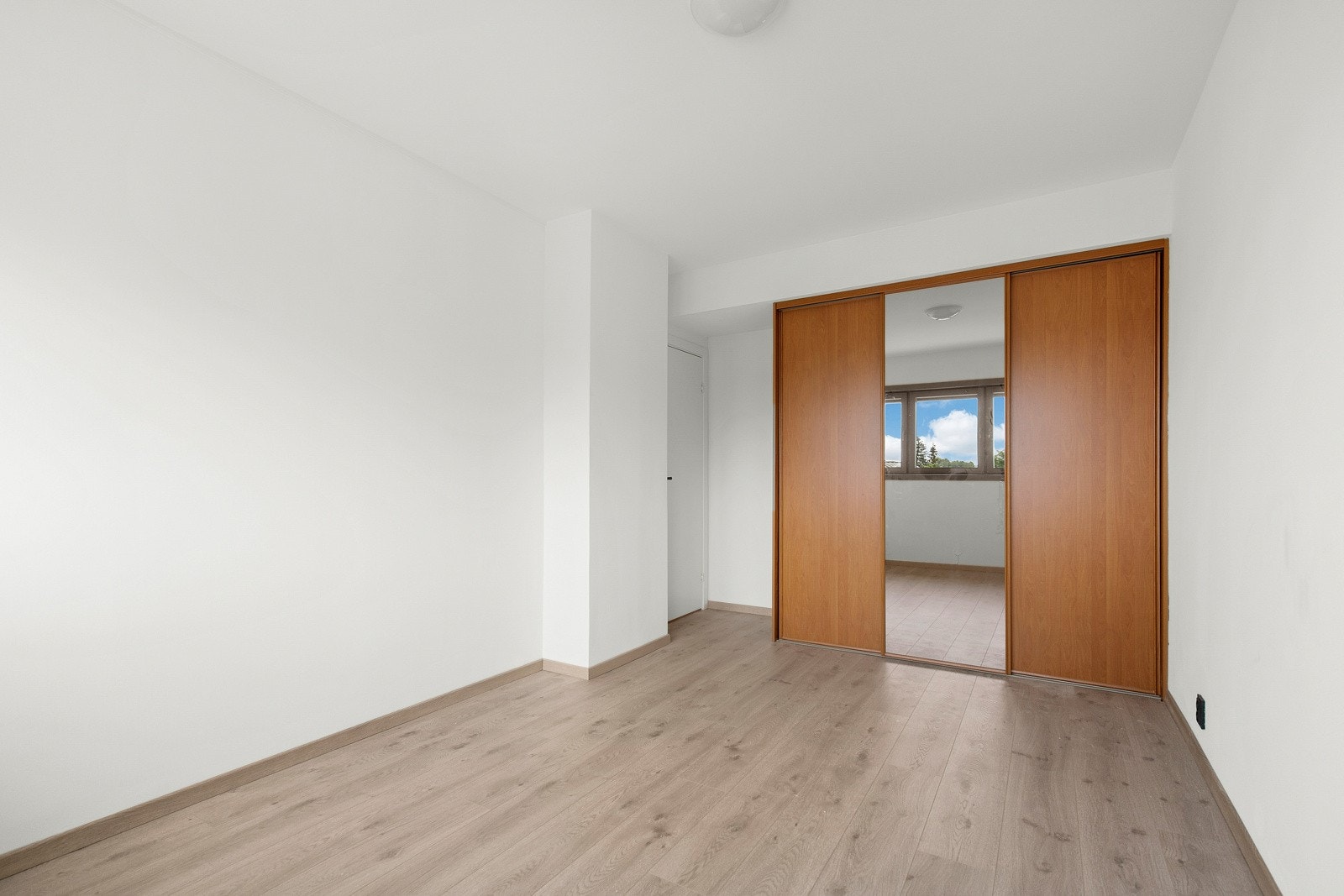 Rommet har god oppbevaringsplass i en skyvedørsgarderobe med en speilfront. Galleribilde
