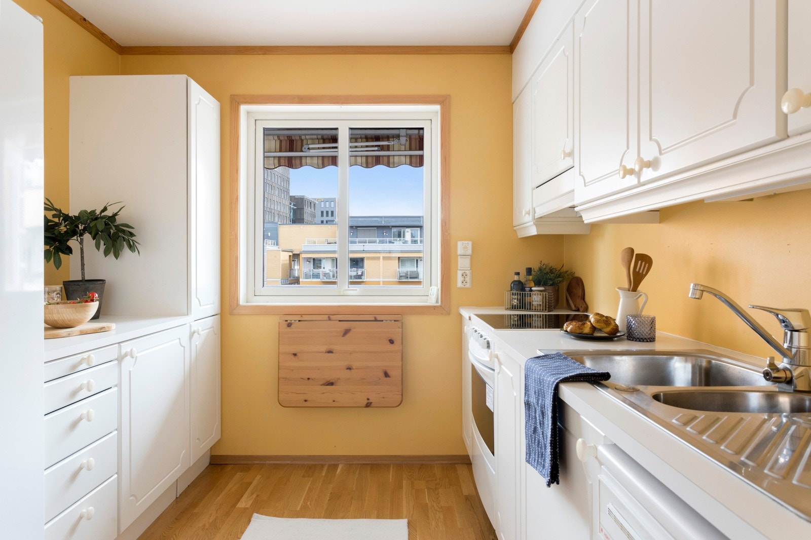 Lyst kjøkken med plass til et lite spisebord. Galleribilde