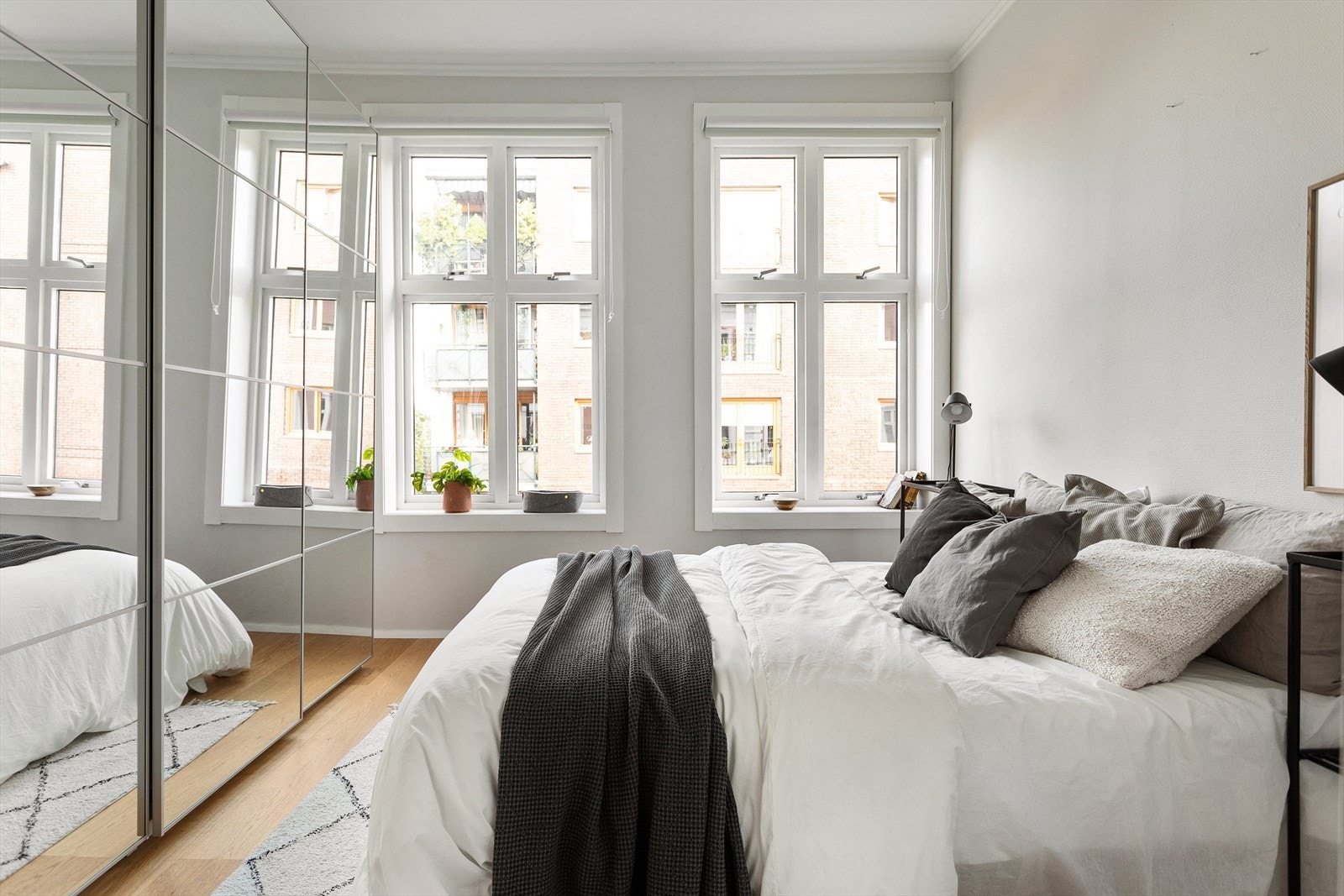 Leiligheten har et romslig soverom med plass til dobbeltseng, nattbord og stor skyvedørsgarderobe Galleribilde