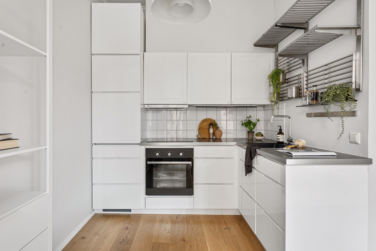 Kjøkkeninnredning med lyse profilerte/glatte fronter, fliser over benkeskap og benkeplater i laminat Galleribilde