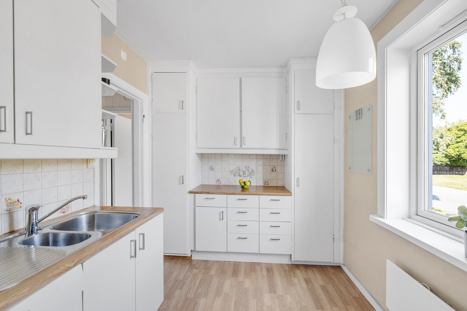 Romslig kjøkken med bl.a. takhøye overskap gir gode oppbevaringsmuligheter. Vindu på kjøkkenet Galleribilde