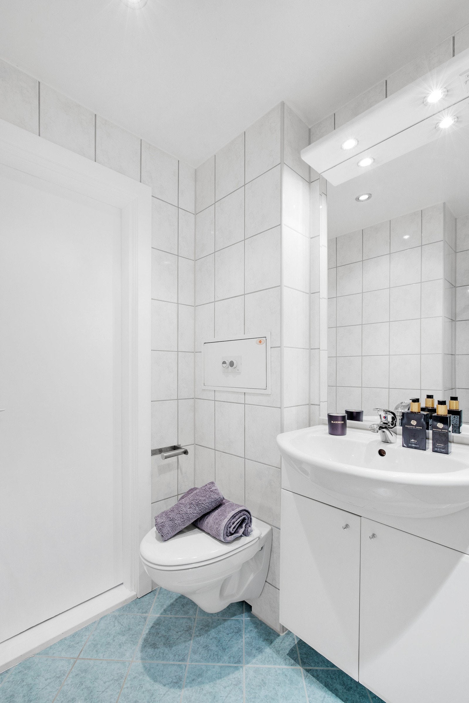 Pent flislagt bad som er pusset opp i regi av brl. i 2005 - Hvit moderne baderomsinnredning og vegghengt toalett Galleribilde