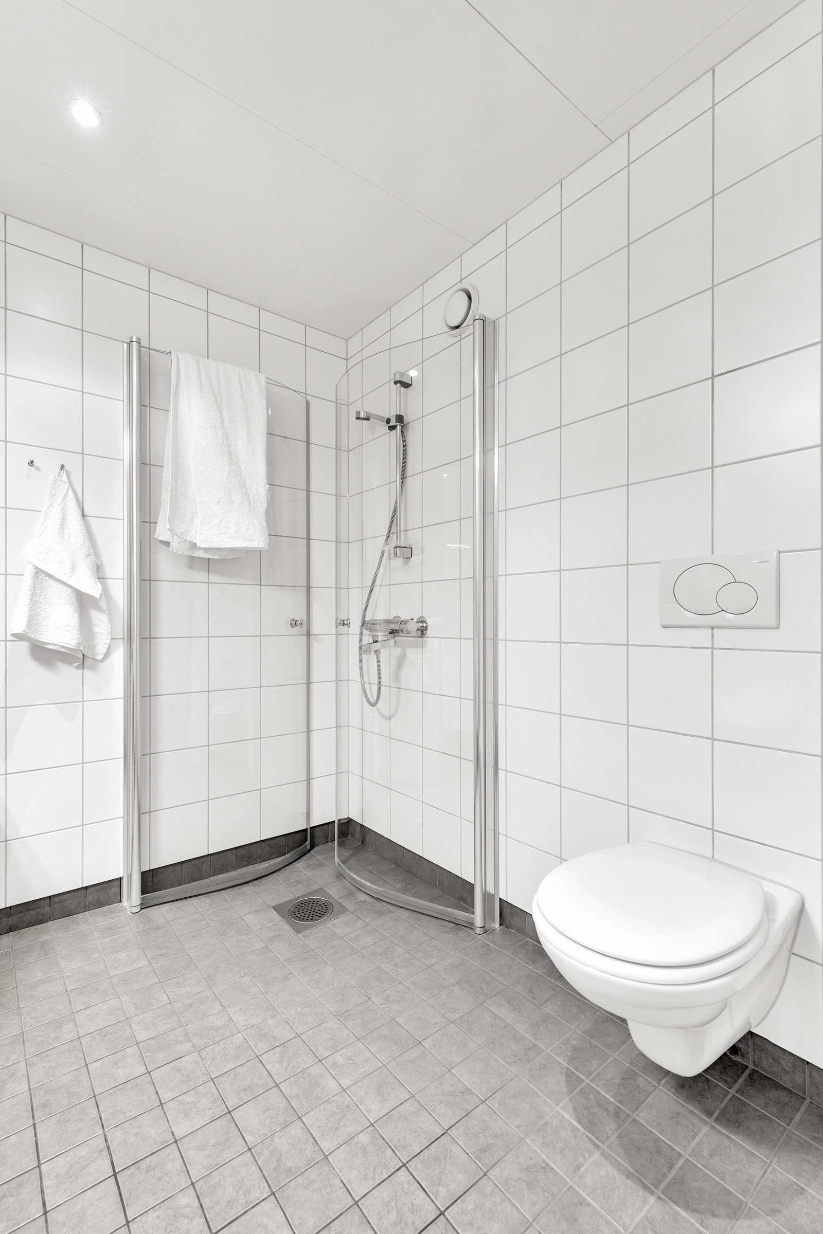 Innredningen består av svingbare dusjdører, vegg hengt toalett og opplegg for vaskemaskin. Galleribilde