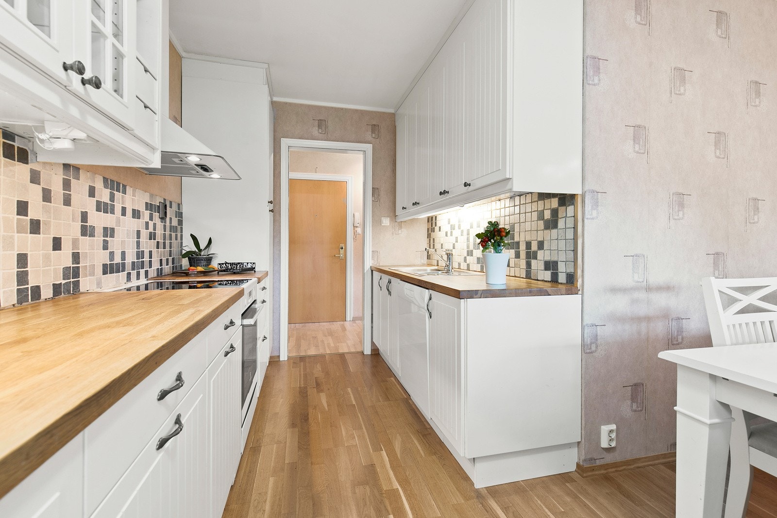 I innredningen er det benkebelysning og over komfyrplassen er det en vegghengt ventilator med kullfilter. Galleribilde