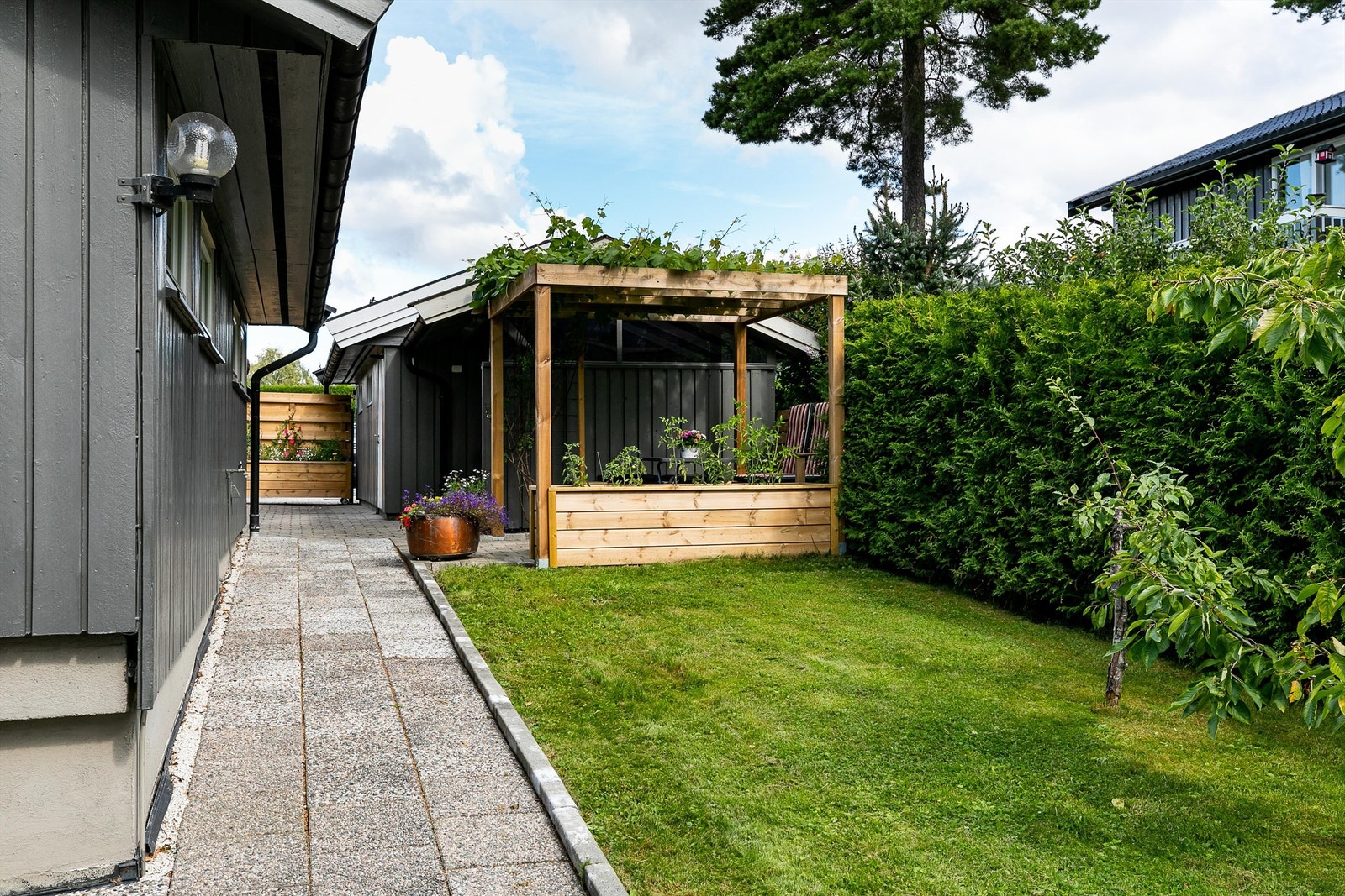 Gangvei med heller og belegningsstein er etablert mellom garasjene og inngangspartiet. Galleribilde