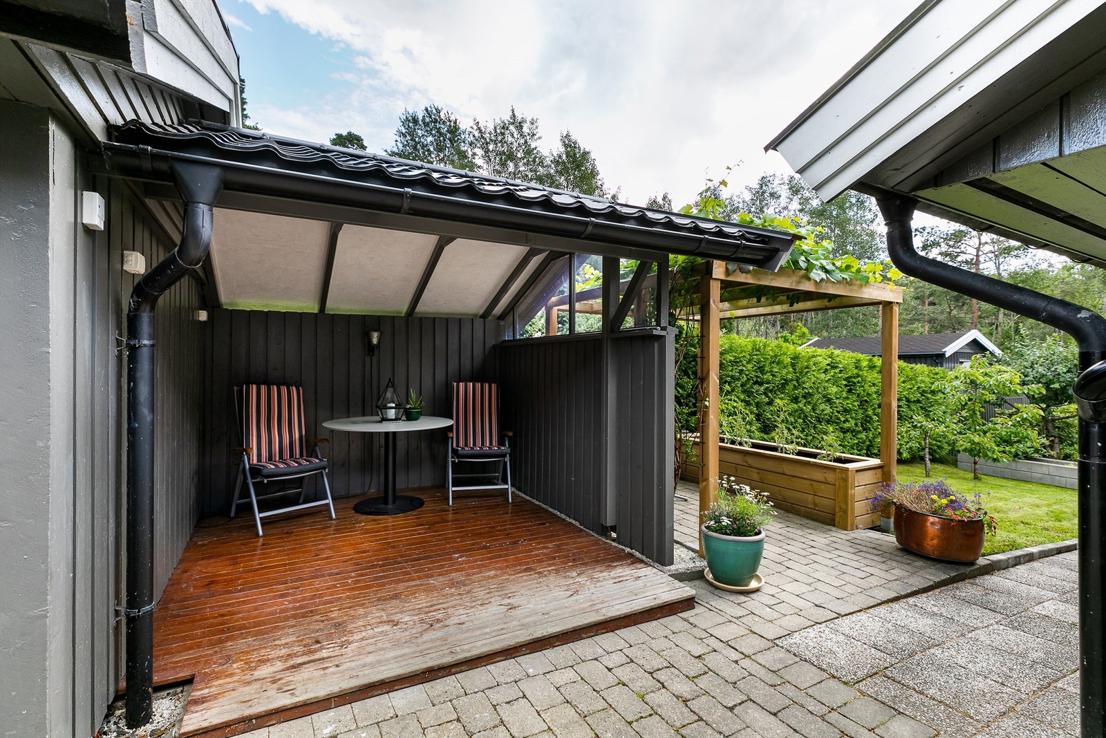 En overbygget og intim hagestue er tilbygget den eldste garasjens sydside. Galleribilde