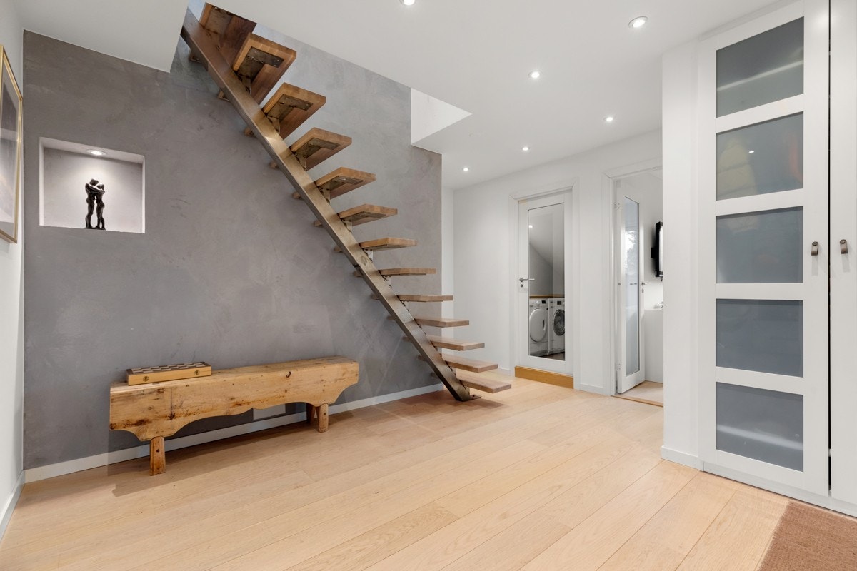 Hall med 1-stavs eikeparkett fra 2016, gulvvarme, downlightsbelysning og garderobeskap. Designtrapp opp til loftsetasje. Galleribilde