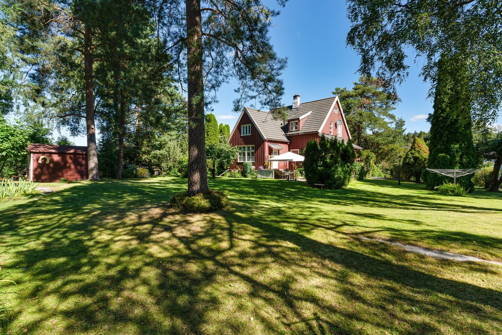 Utvendig omkranses huset av en idyllisk hage og velstelt tomt med vakker beplantning som blomstrer til forskjellige tider av året. Galleribilde