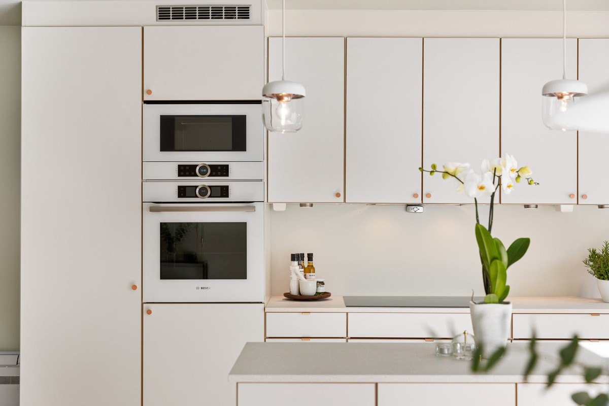 Kompositt kum og kjøkkenarmatur i farge hvitt fra BLANCO nedfelt i laminat benkeplate og kullfiltervifte fra WITT. Innfelt LED belysning i himling med dimmer over kjøkkenbenk. Galleribilde