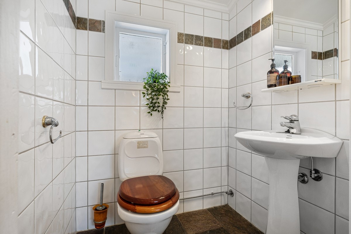 Praktisk toalettrom med skifer fliser på gulv og keramiske fliser på vegger. Galleribilde