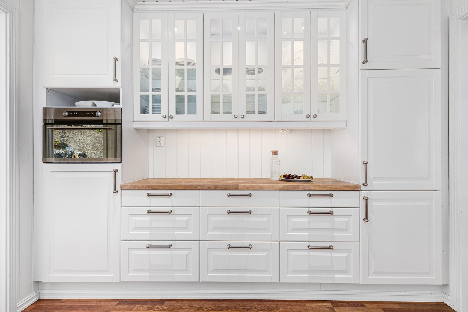 Benkeflatene er i heltre og det et er lagt pene hvite fliser i overgang mellom overskap og benkeplater. Galleribilde