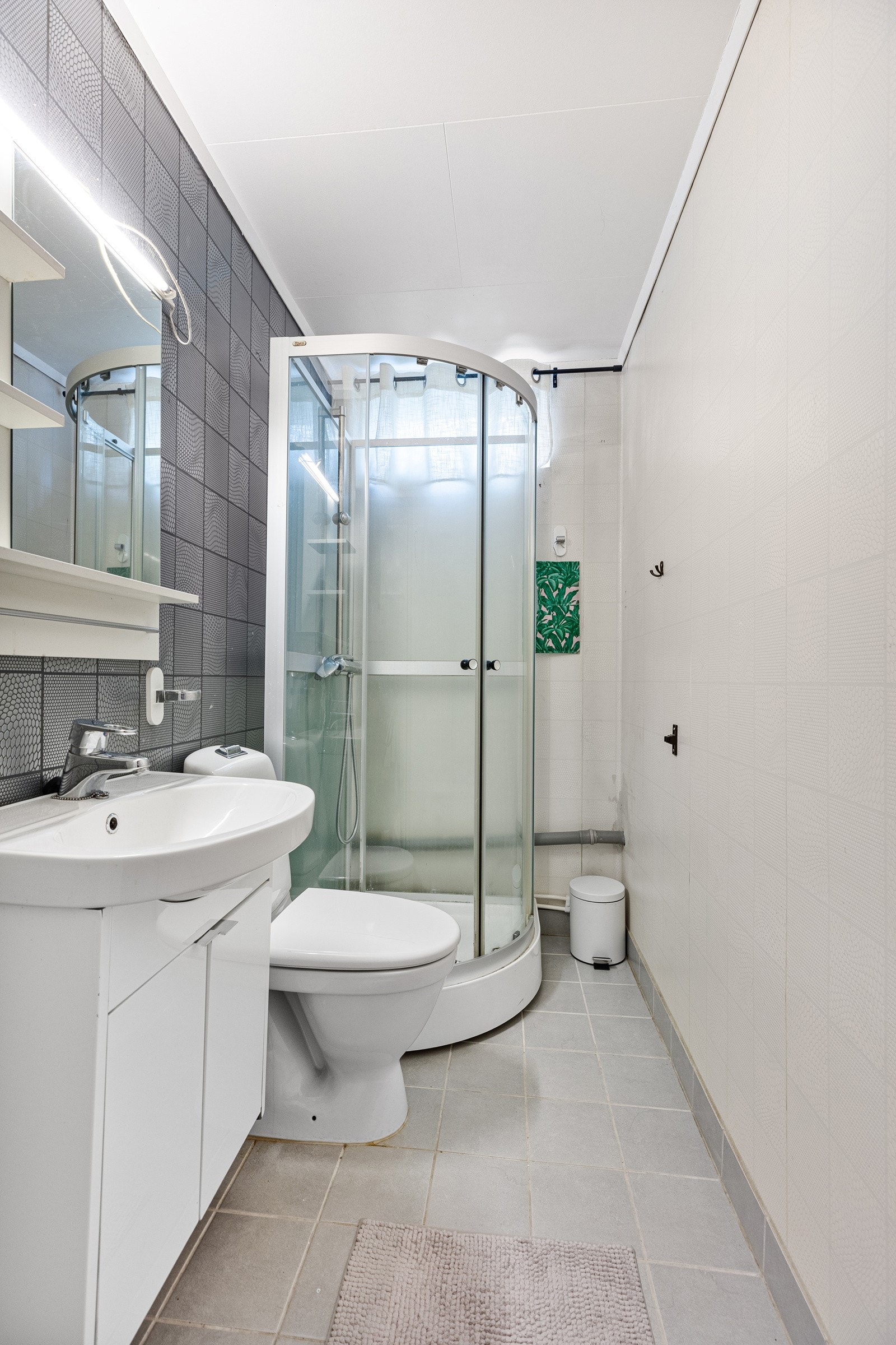 Badet har fliser på vegg og gulv med varmekabler i gulvet. Galleribilde