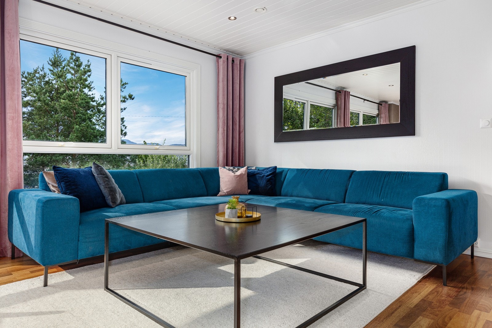 Sofadelen i stuen med flott utsikt mot hagen. Galleribilde