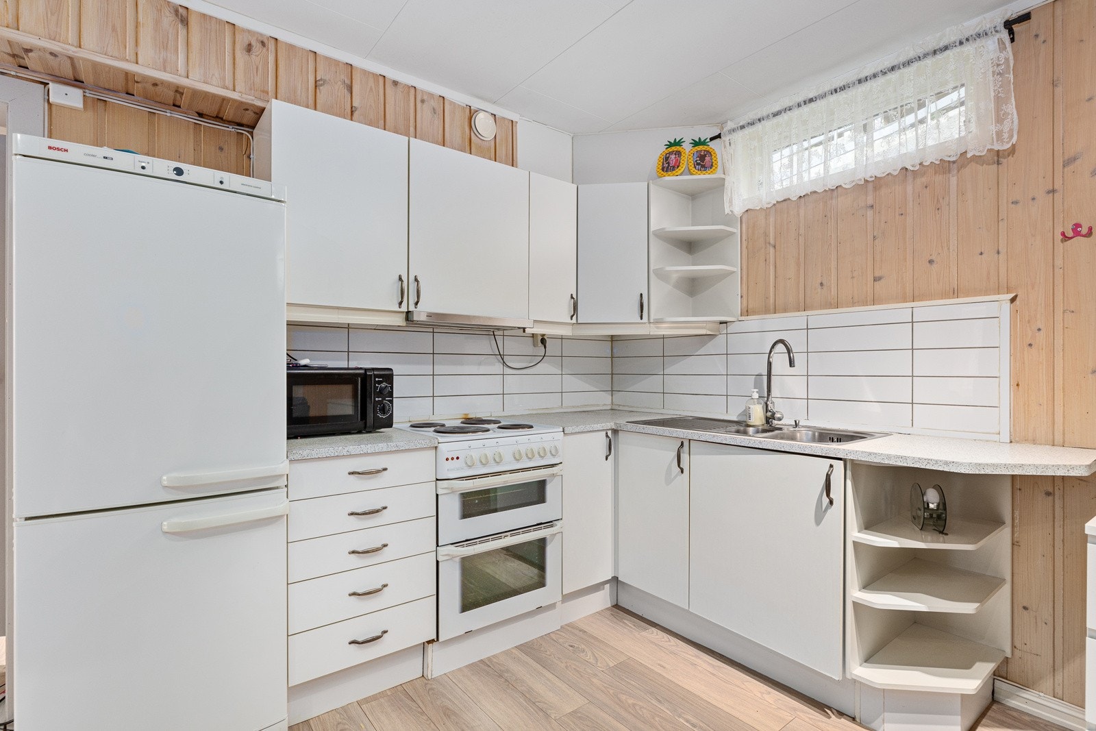 Kjøkkenet har hvite fronter og servant. Galleribilde