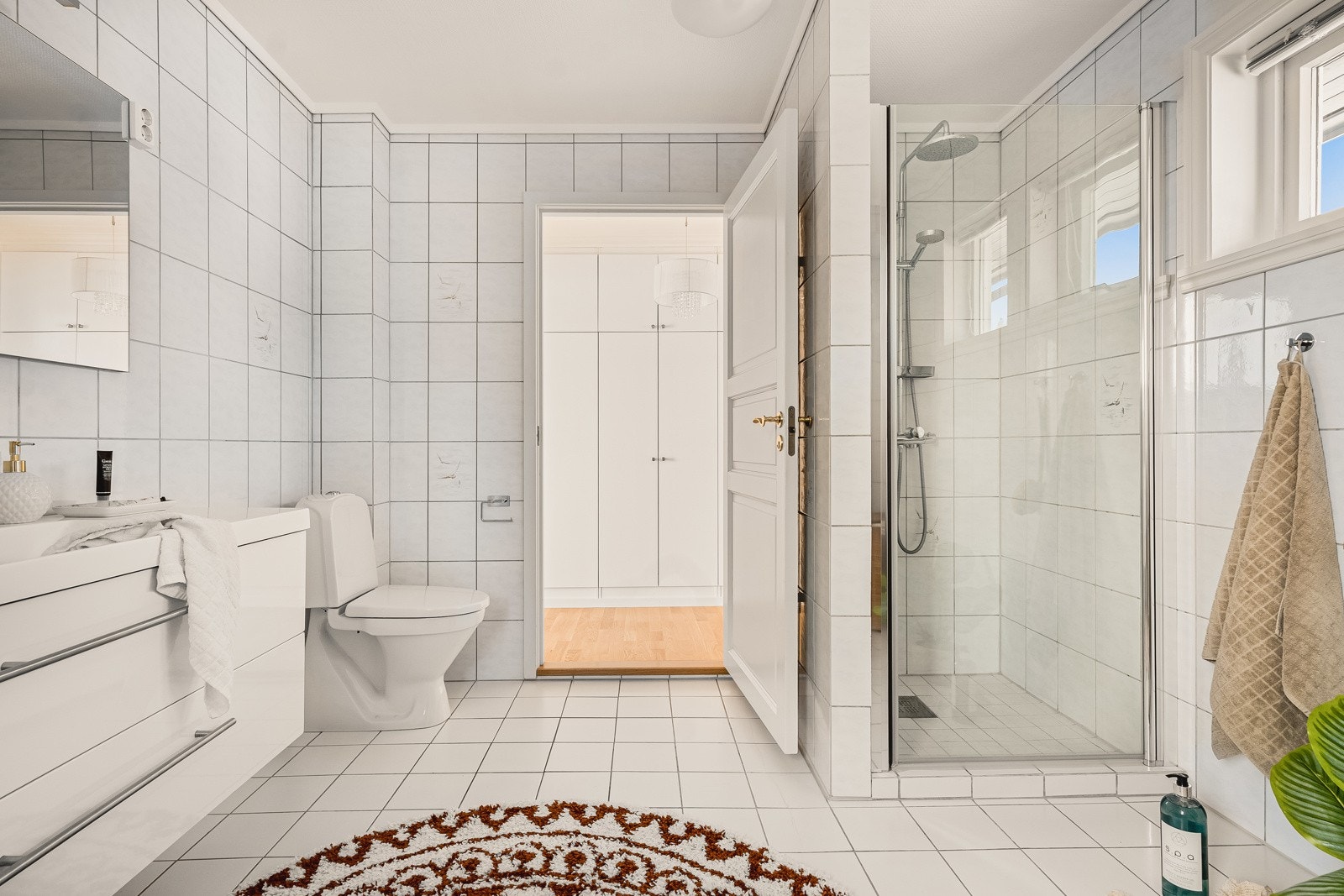 Inneholder benkeskap med servant, gulvmontert toalett, dusjdør og opplegg for badekar. Galleribilde