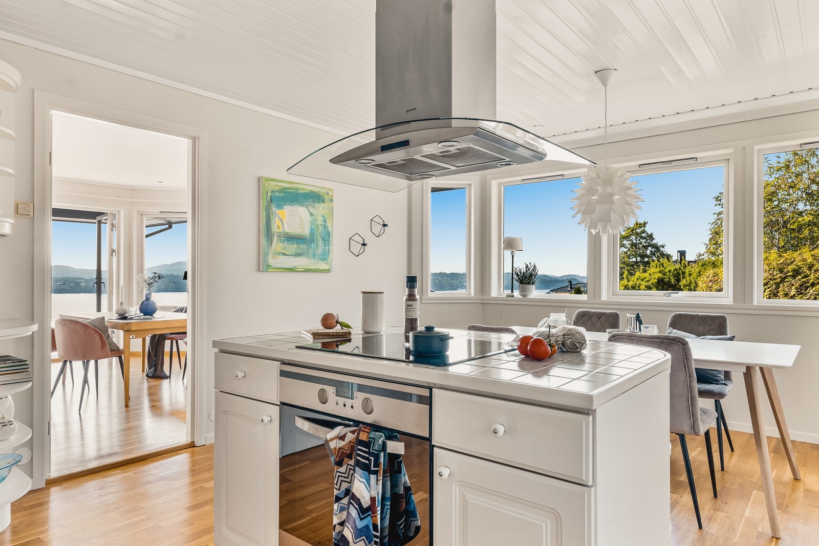 Kjøkkeninnredning med hvite profilerte fronter og benkeplate i laminat med nedfelt vask. Galleribilde