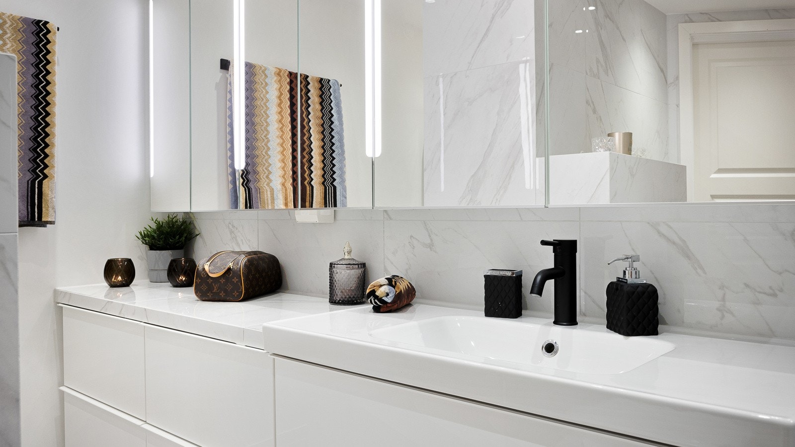 Baderommet er gjennomført og har lekre, lyse fliser og overflater. Galleribilde