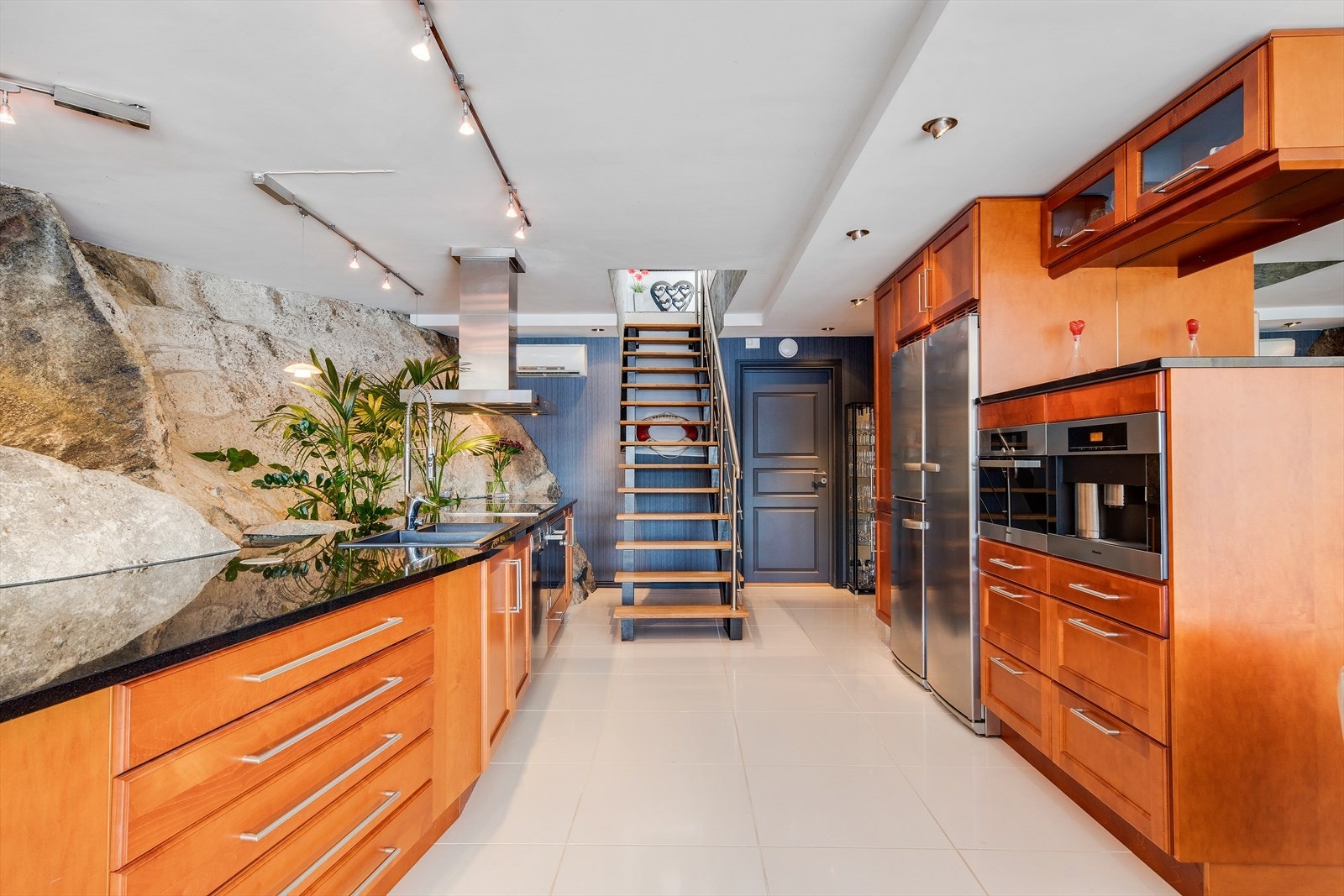 Kjøkkenet har alt som trengs for kokkelering på høyt nivå. Benkeplaten er i sort granitt og har sort oppvaskkum. Galleribilde