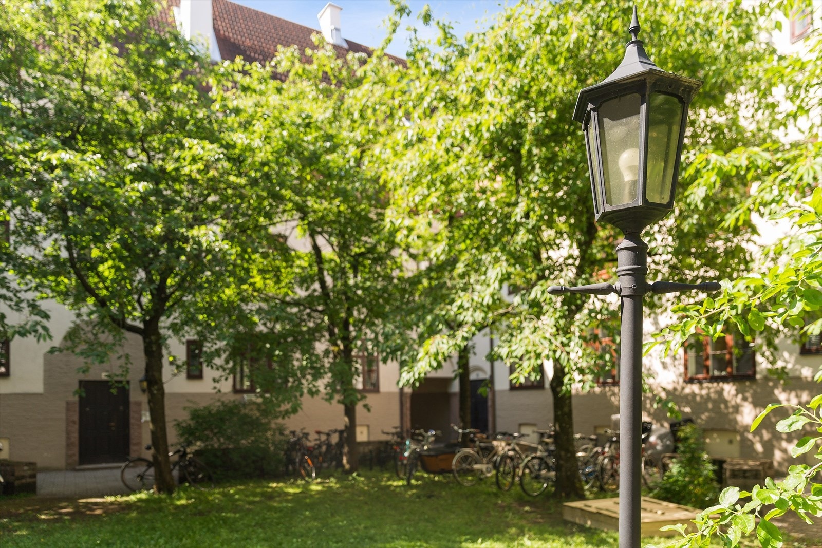 Pent opparbeidet gårdsrom med felles hage, sittegrupper, sykkelparkering, betong- og beledningsstein, trær og beplantning Galleribilde