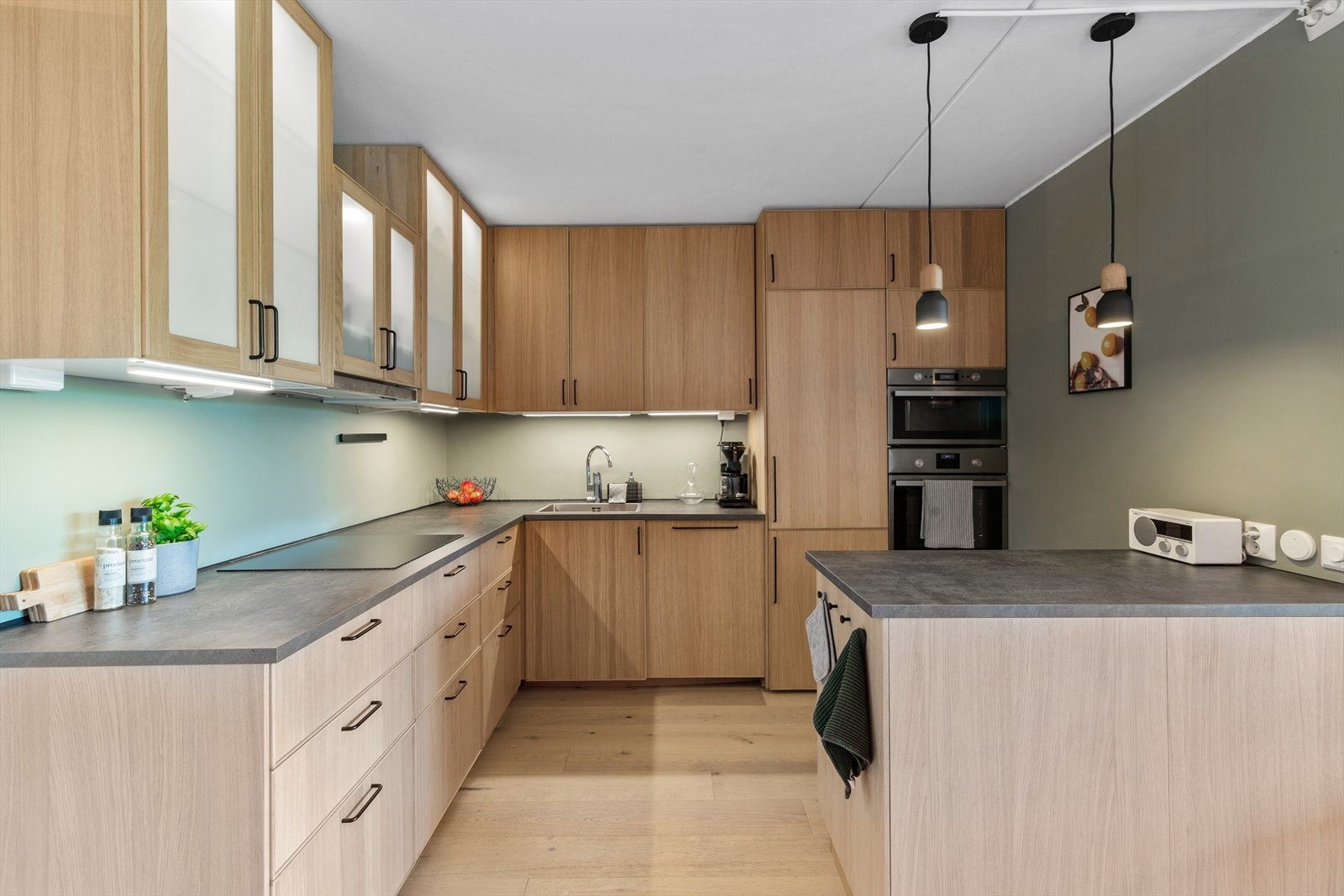 Det åpne og meget stilige kjøkkenet har massevis av god skap- og benkeplass, perfekt for hobbykokken! Her er det takhøy innredning fra 2018 med glatte, folierte fronter samt seks vitrinedører og laminat benkeplate med nedfelt kum i rustfritt stål. Galleribilde