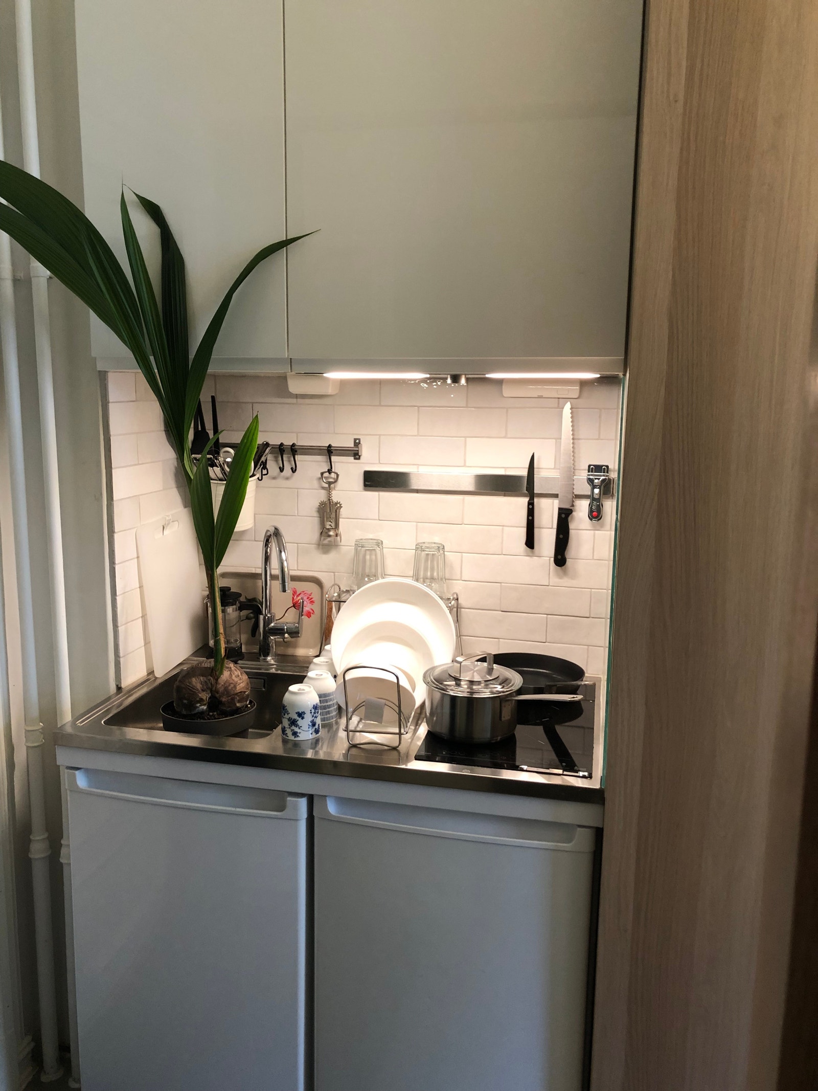 Flott kompaktkjøkken med keramisk platetopp og kjøleskap. Galleribilde