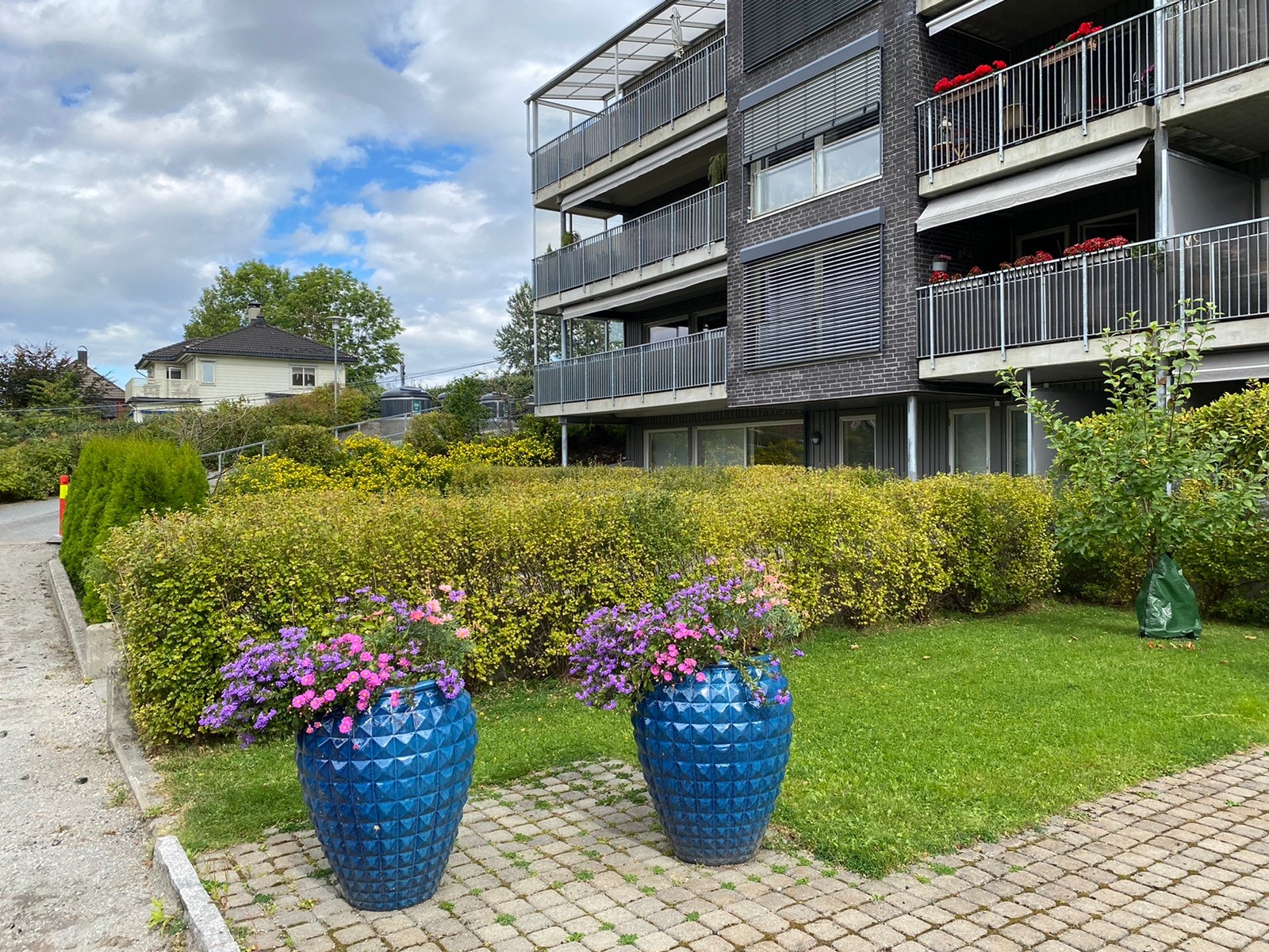 Felles uteområde skjermes fra biltrafikk og støy av de omkransende boligblokkene og er en liten grønn oase kun 500 m fra asker sentrum og togstasjonen Galleribilde