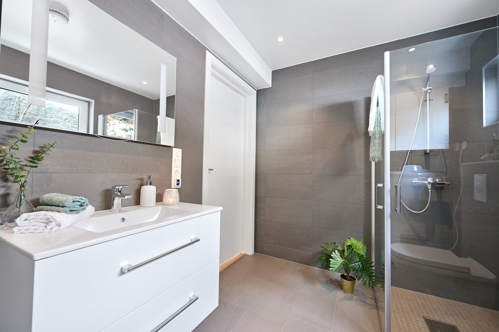 Baderom med wc, servant og dusjhjørne. Her er det opplegg for vaskemaskin. Galleribilde