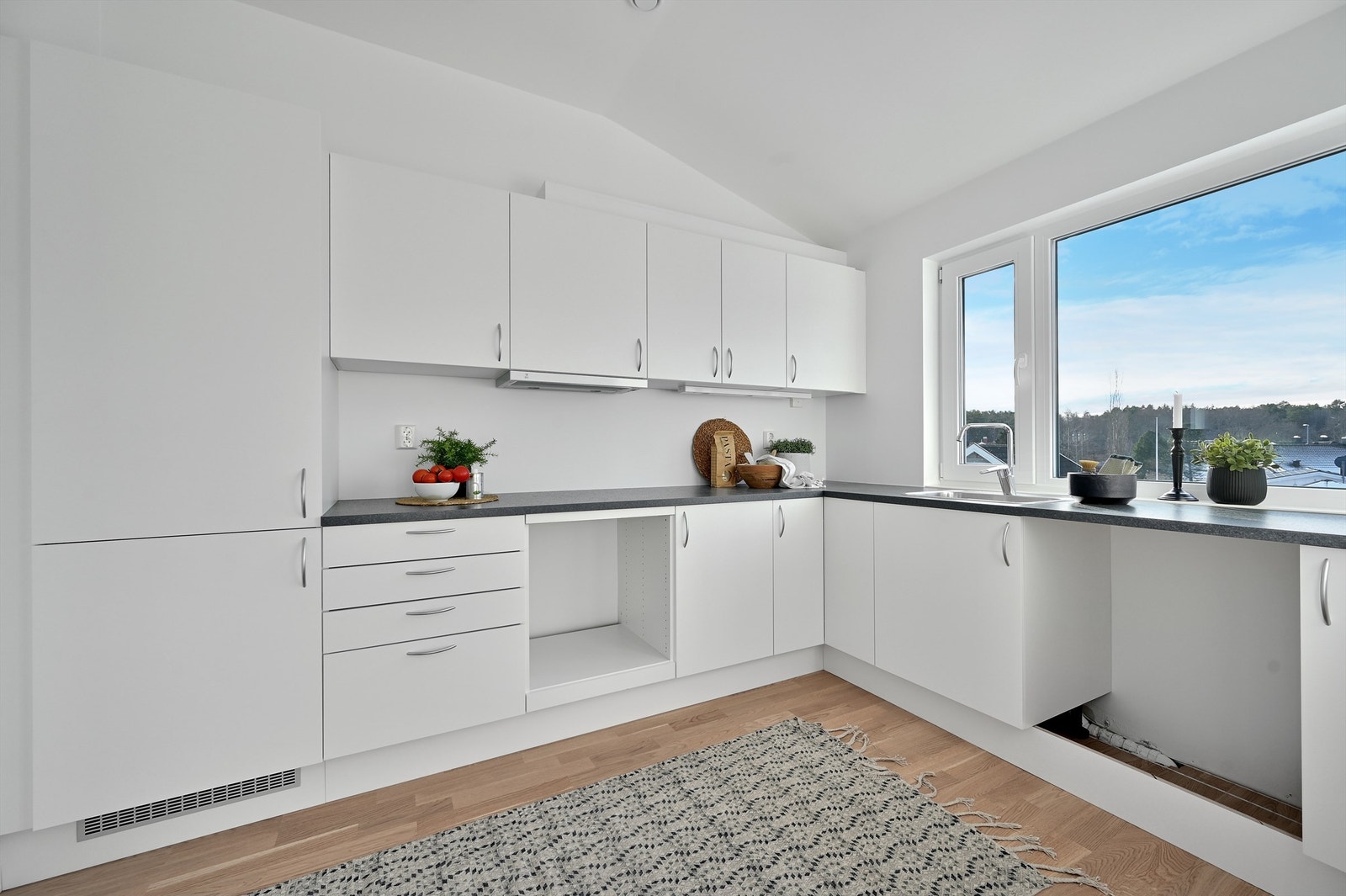 Lyst og lekkert kjøkken med god skap og benkeplass Galleribilde