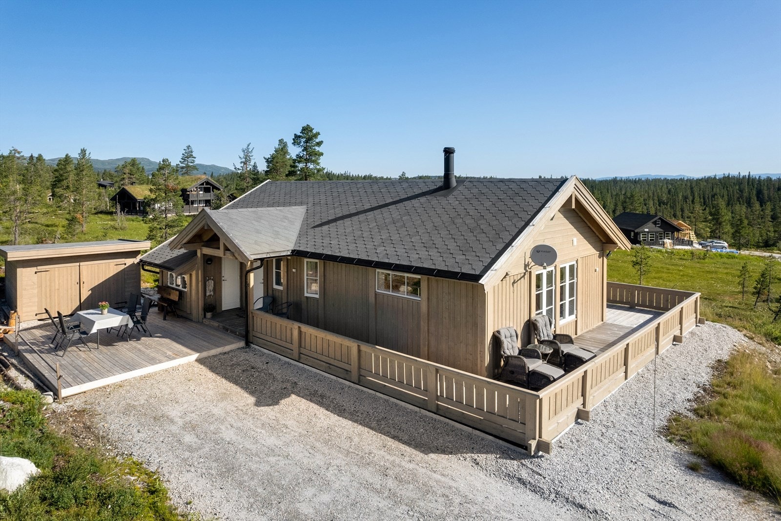 Deilig terrasseplatting ved inngangspartiet som fortsetter rundt deler av hytta. Galleribilde