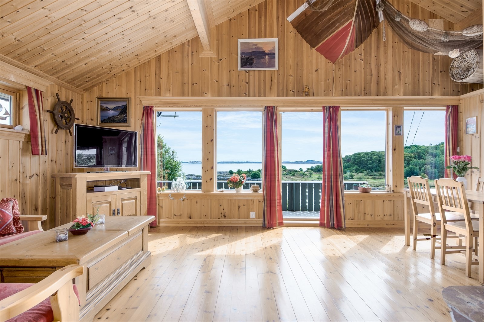Stue med høy himling og store vindusflater mot sjø. Galleribilde