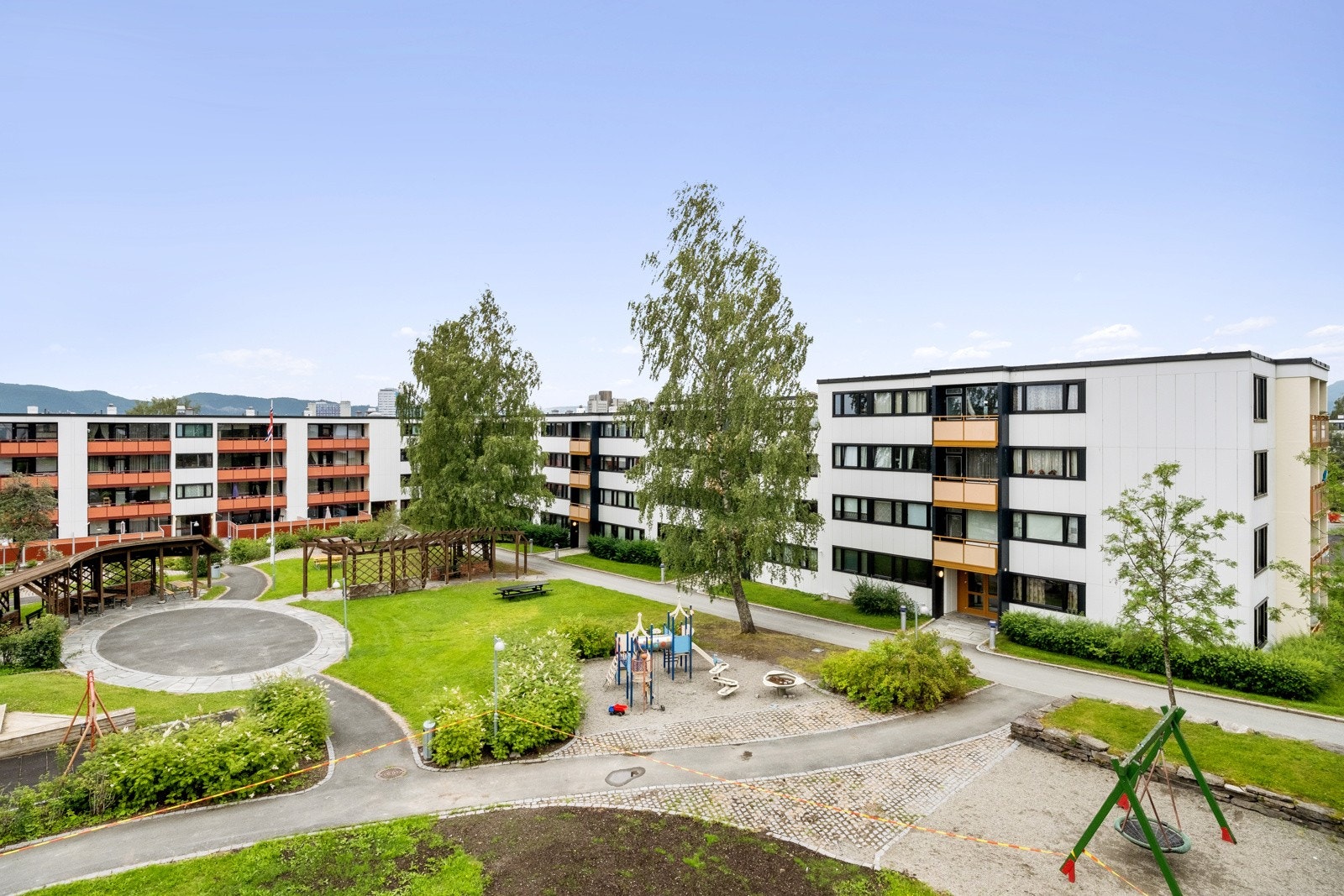 Tunet er parkmessig opparbeidet med lekeapparater, pergola, sittegrupper under tak og asfalterte internveier. Galleribilde