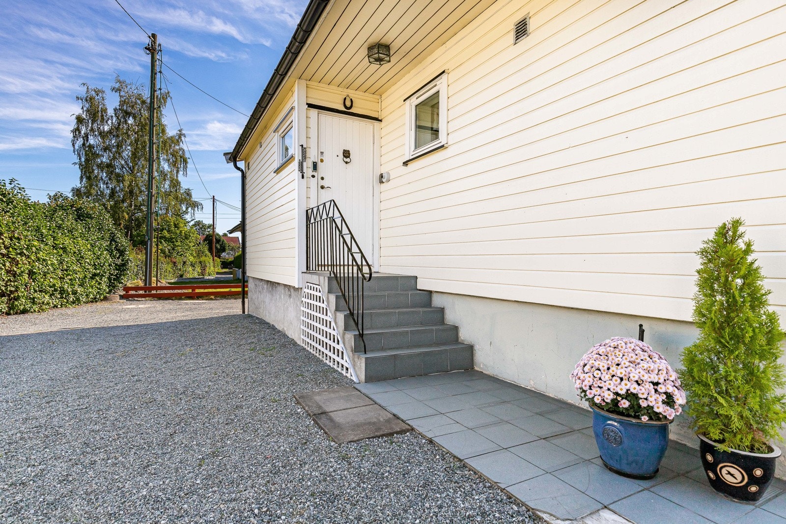 På baksiden av eneboligen er det et overbygd inngangsparti med flislagt trapp. Galleribilde