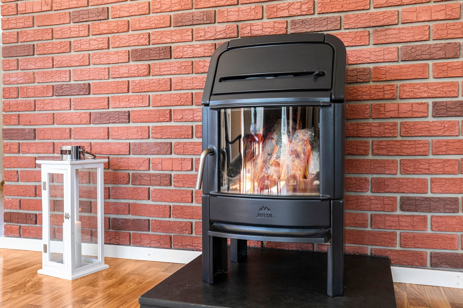 Ovnen er montert på en rød teglsteinsvegg. Galleribilde