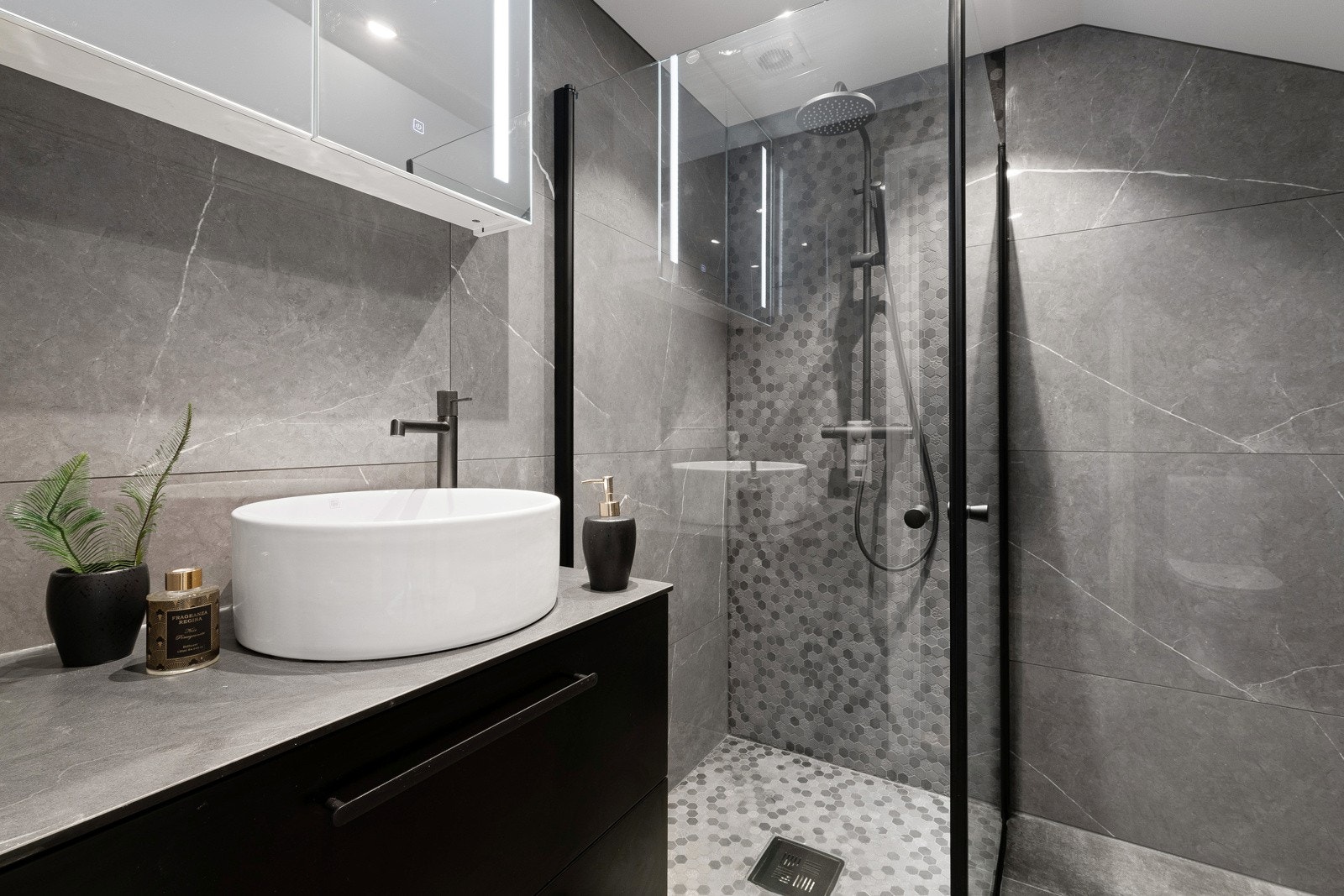 Av innredning finnes sort skuffeseksjon med toppmontert servant og speilskap med integrert belysning. Galleribilde