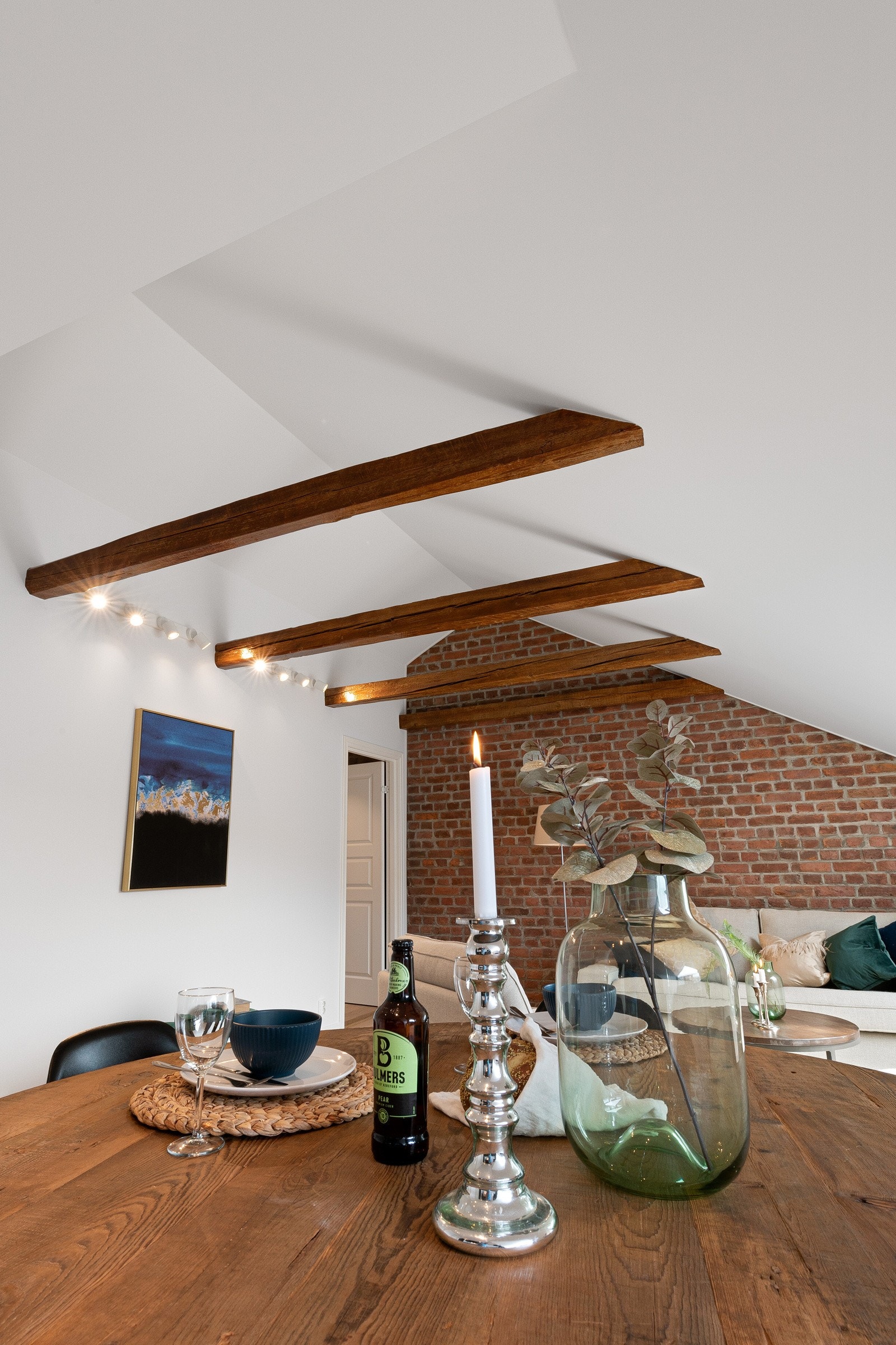 Kraftige bærebjelker og rød tegl er et stilig innslag til det stilrene. Galleribilde