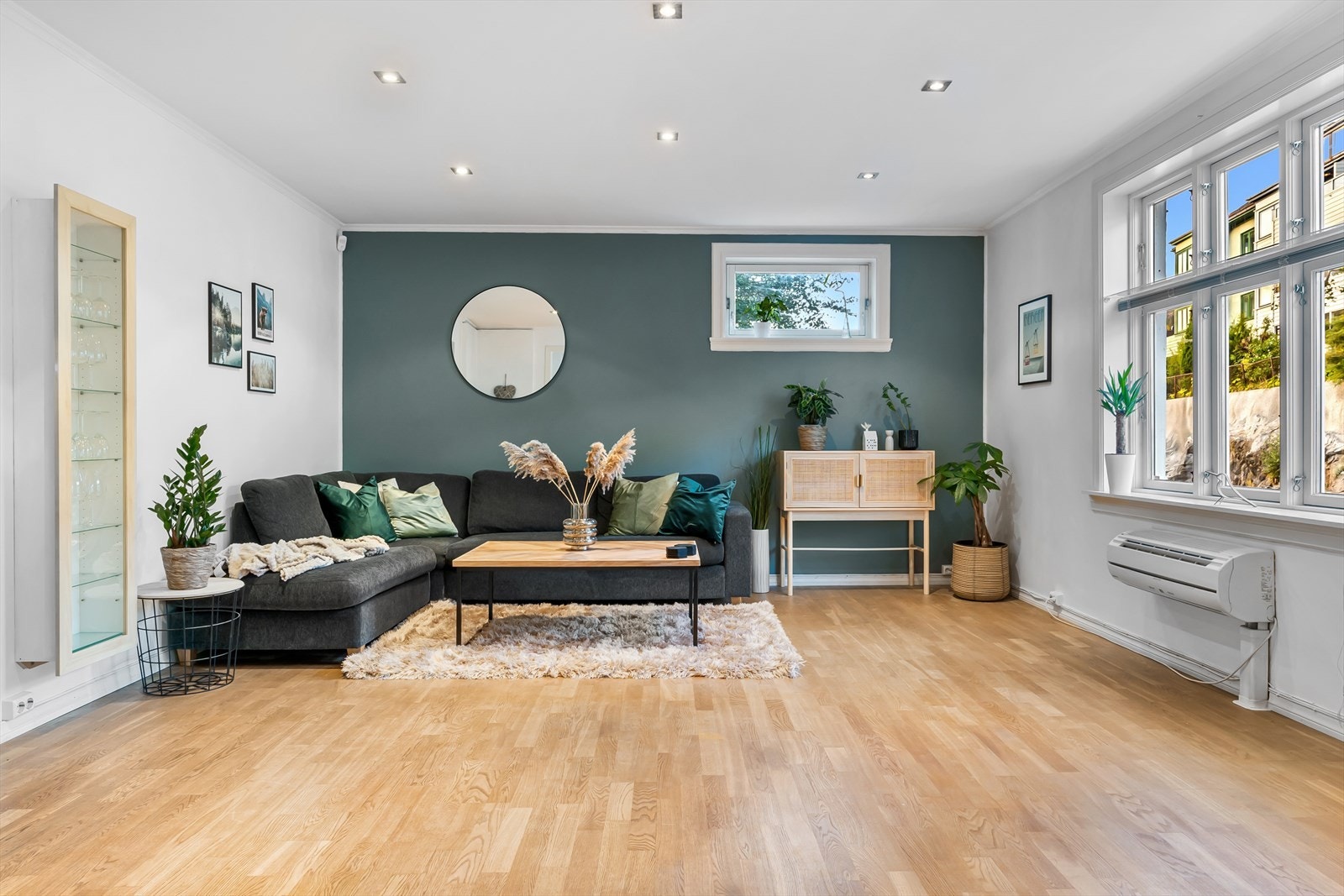 Leiligheten har en åpen stue- og kjøkkenløsning, her er det lysmalt med en flott brytningsvegg ved sofa. Galleribilde