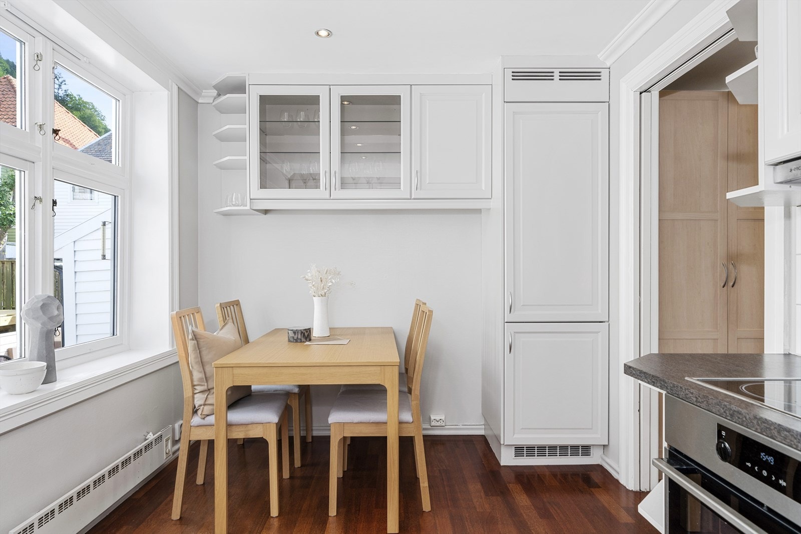 Rommet er godt utnyttet med overskap med hyller og vitrineskap over spiseplassen på kjøkkenet. Galleribilde