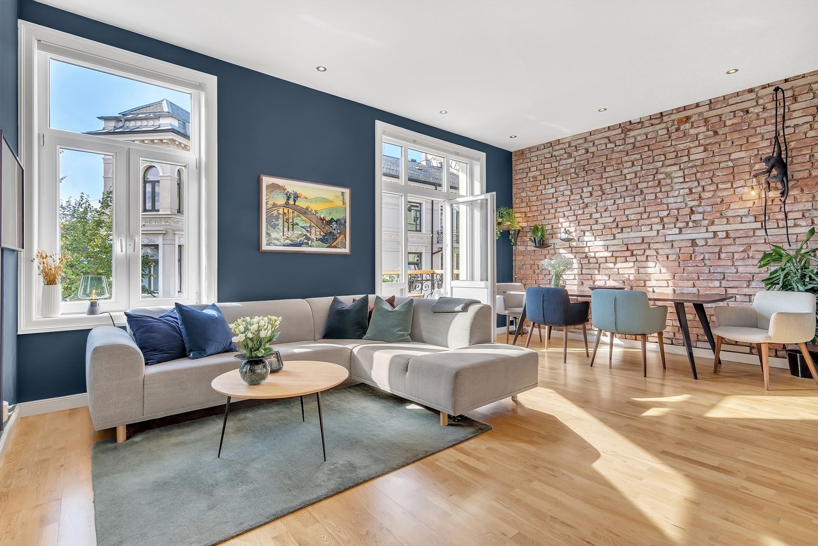 Romslig stue med god plass til sofaseksjon og spisebord. Legg merke til den flotte originale teglsteinsveggen. Galleribilde