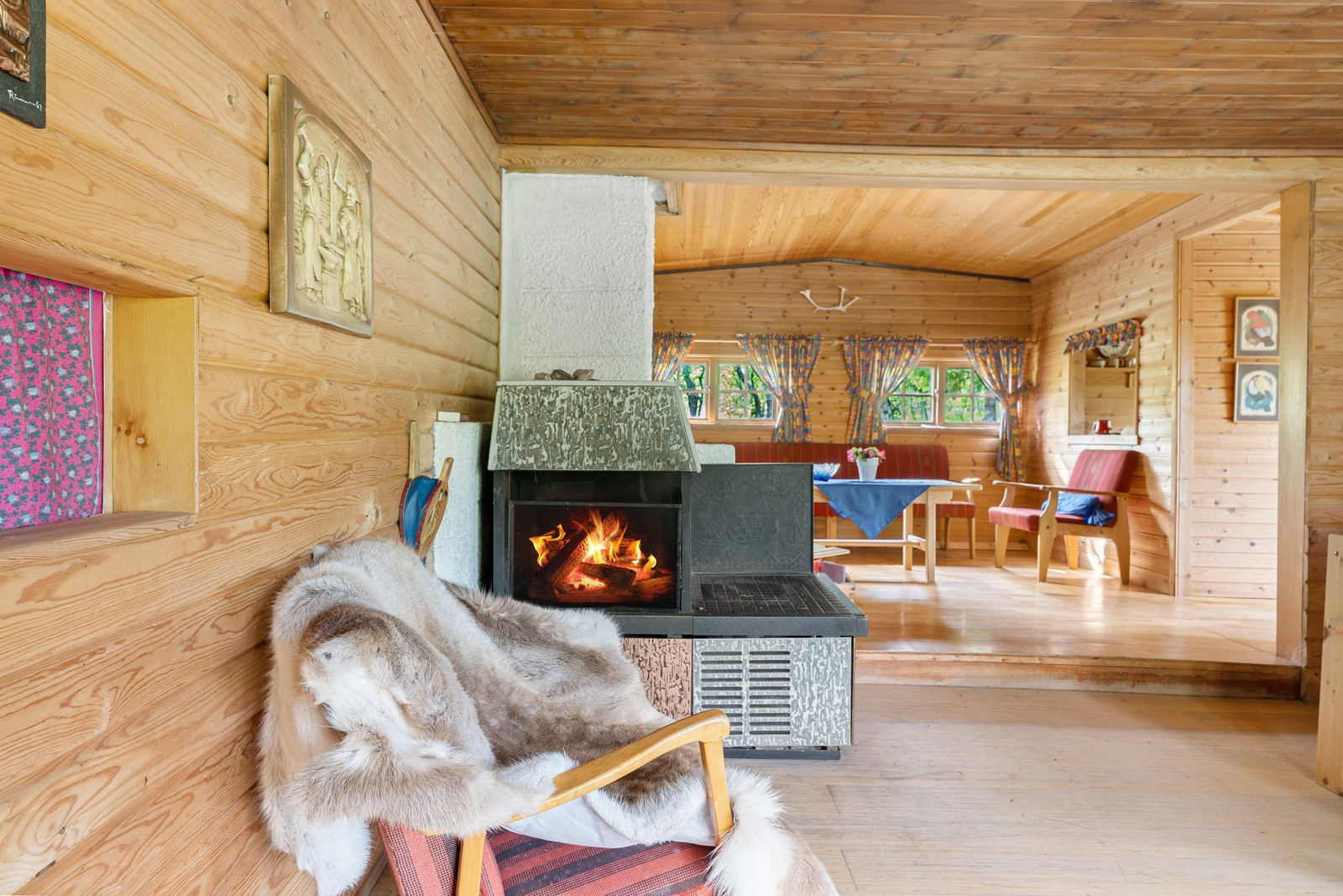 Den store stuen skaper rom for to individuelle oppholdssoner- peisen skaper et skille mellom de to